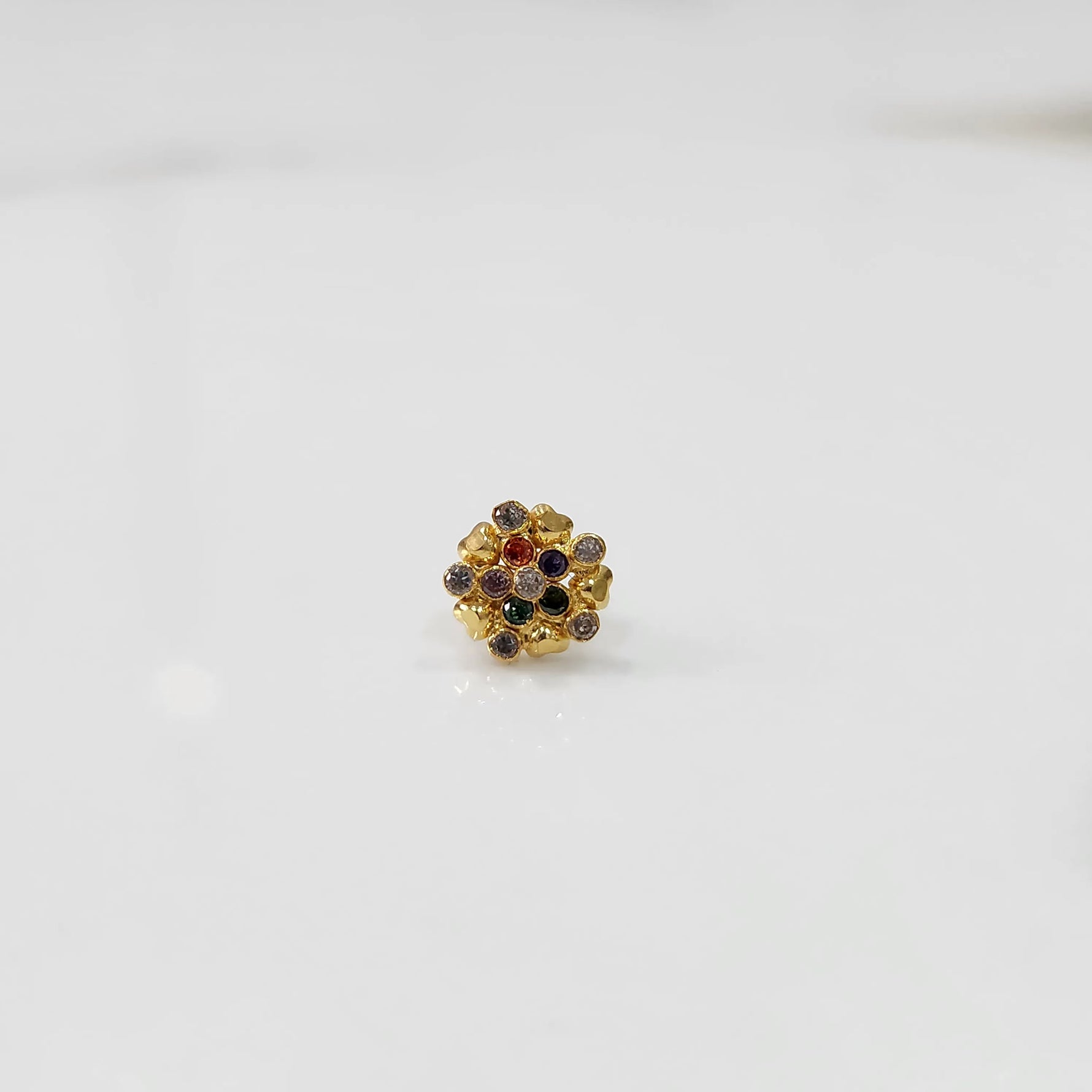 Close-up of gold statement ring with multicolor gemstones in textured flower cluster setting