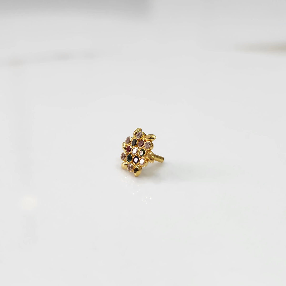 Gold statement ring with multicolor gemstones in leaf-patterned floral cluster design