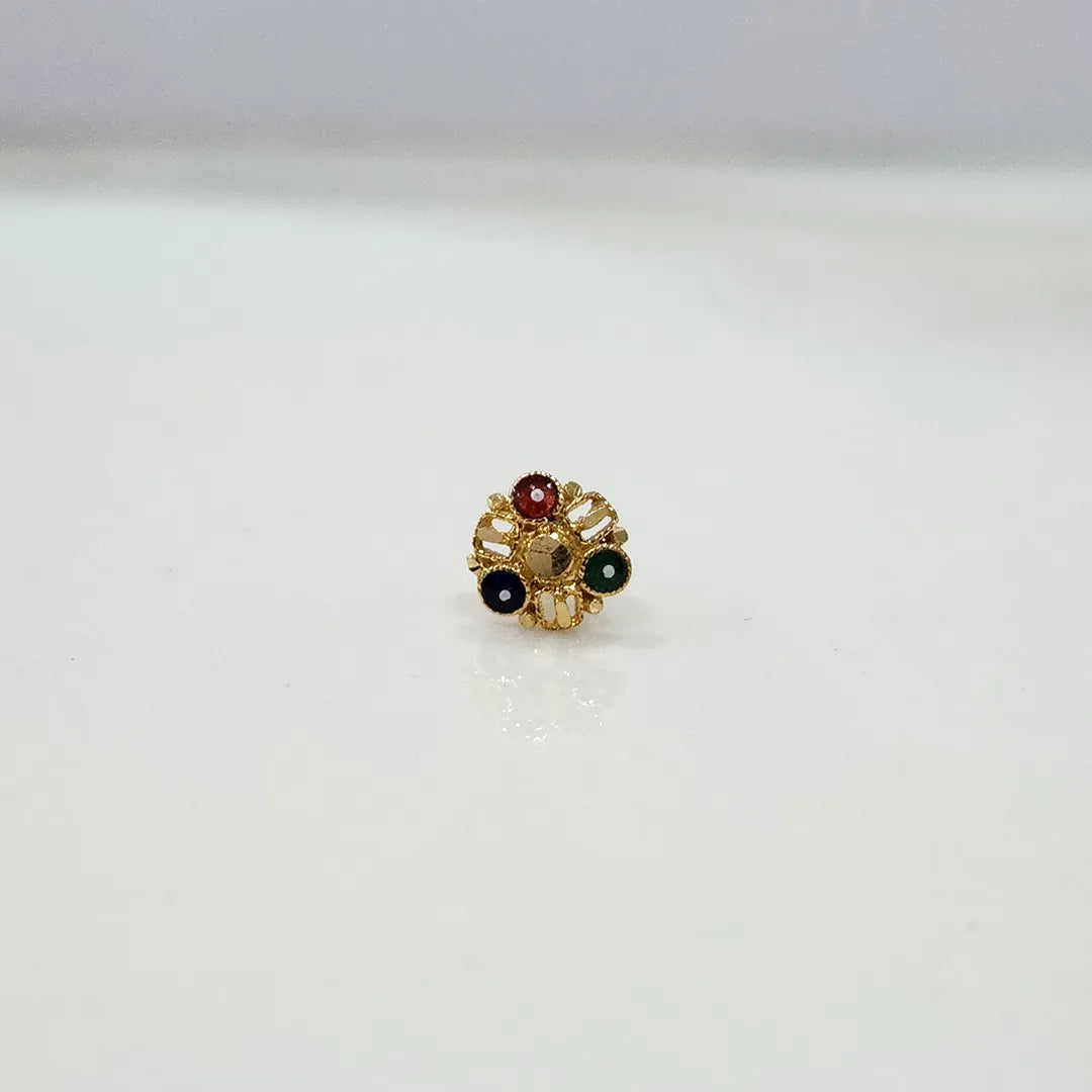 Front view of a gold nose pin with red, green, black, and gold gemstones in a floral cluster design