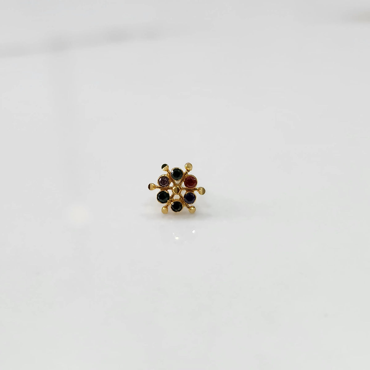 Close-up of gold statement ring with multicolor gemstones in scattered dotted cluster design