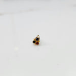 Gold nose pin with blue, black, and red stones, product shot