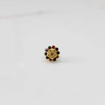 Top view of gold floral nose pin with navratna multicolor stones