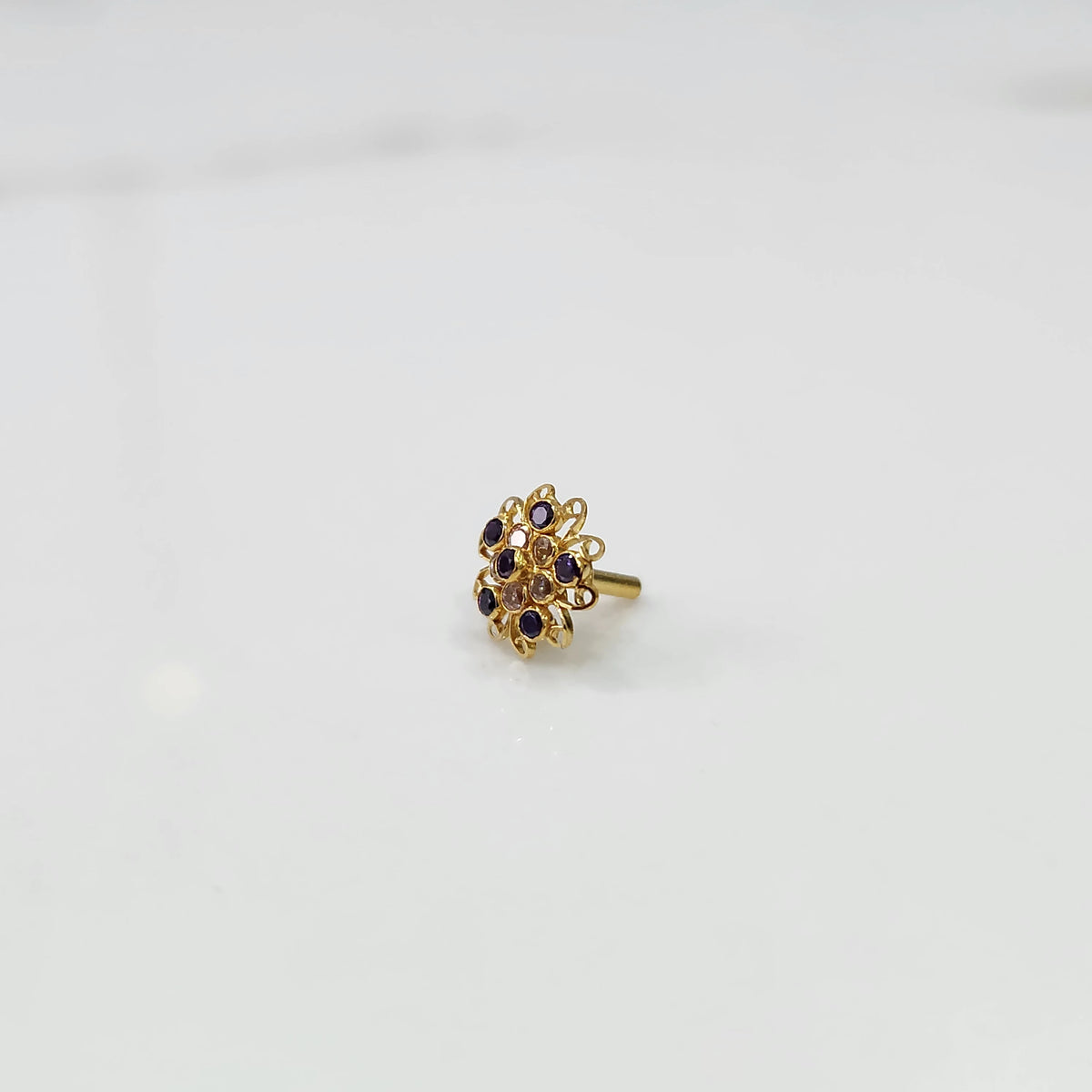 Gold nose pin with purple and champagne round stones in petal-style swirl border