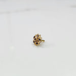 Gold nose pin with purple and champagne round stones in petal-style swirl border