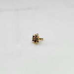 Gold nose pin featuring six-point star design with purple and champagne stone cluster