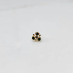 Gold nose pin with black and purple stones in organic branch-style setting