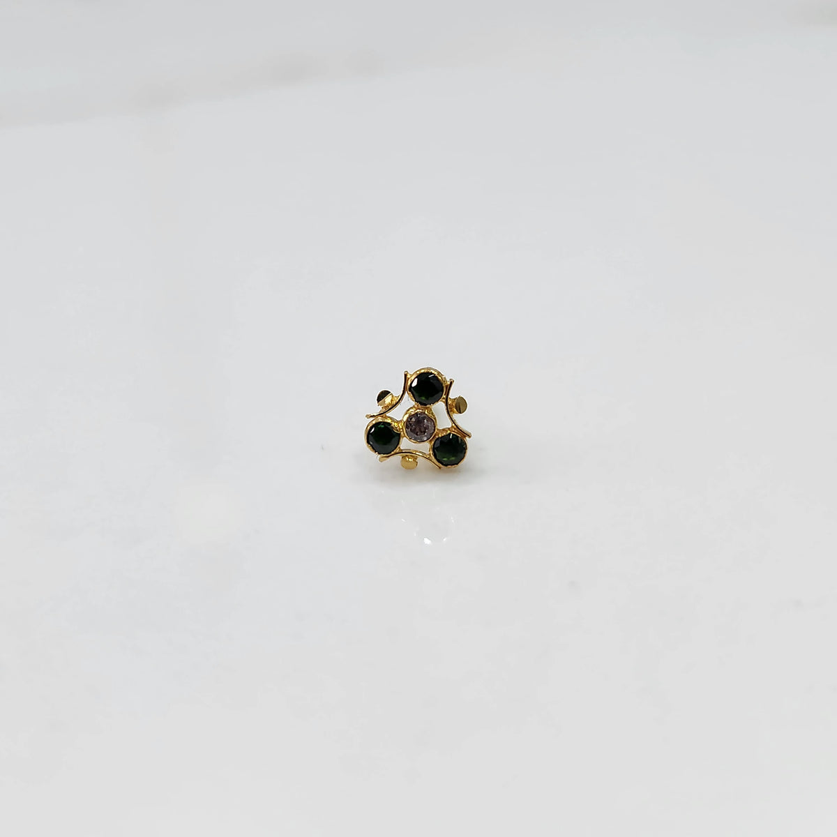 Gold nose pin with black and purple stones in organic branch-style setting