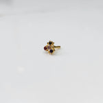 Traditional gold nose stud with black, red, pink, and purple stones in freeform setting