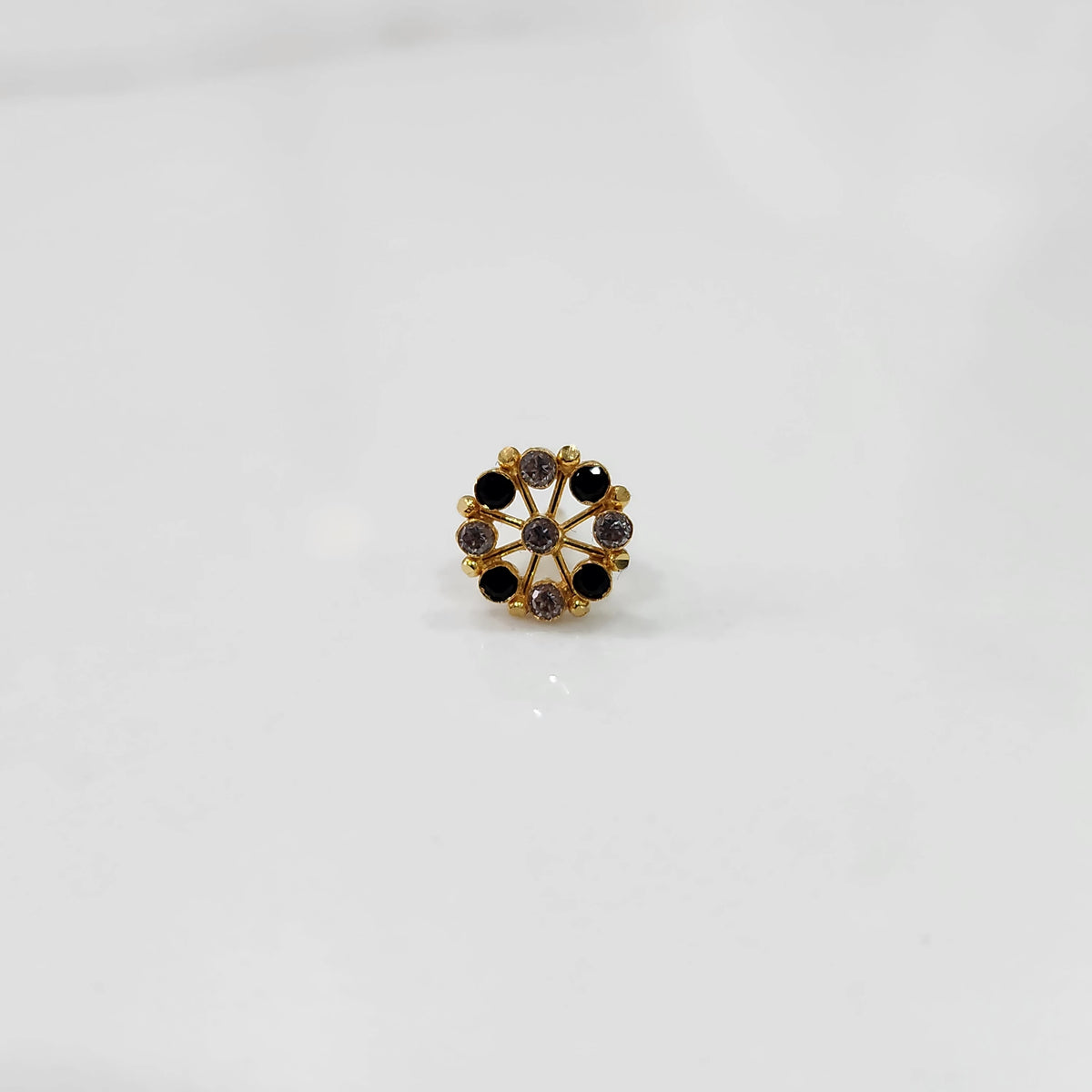 Gold floral nose pin with black and clear stone accents