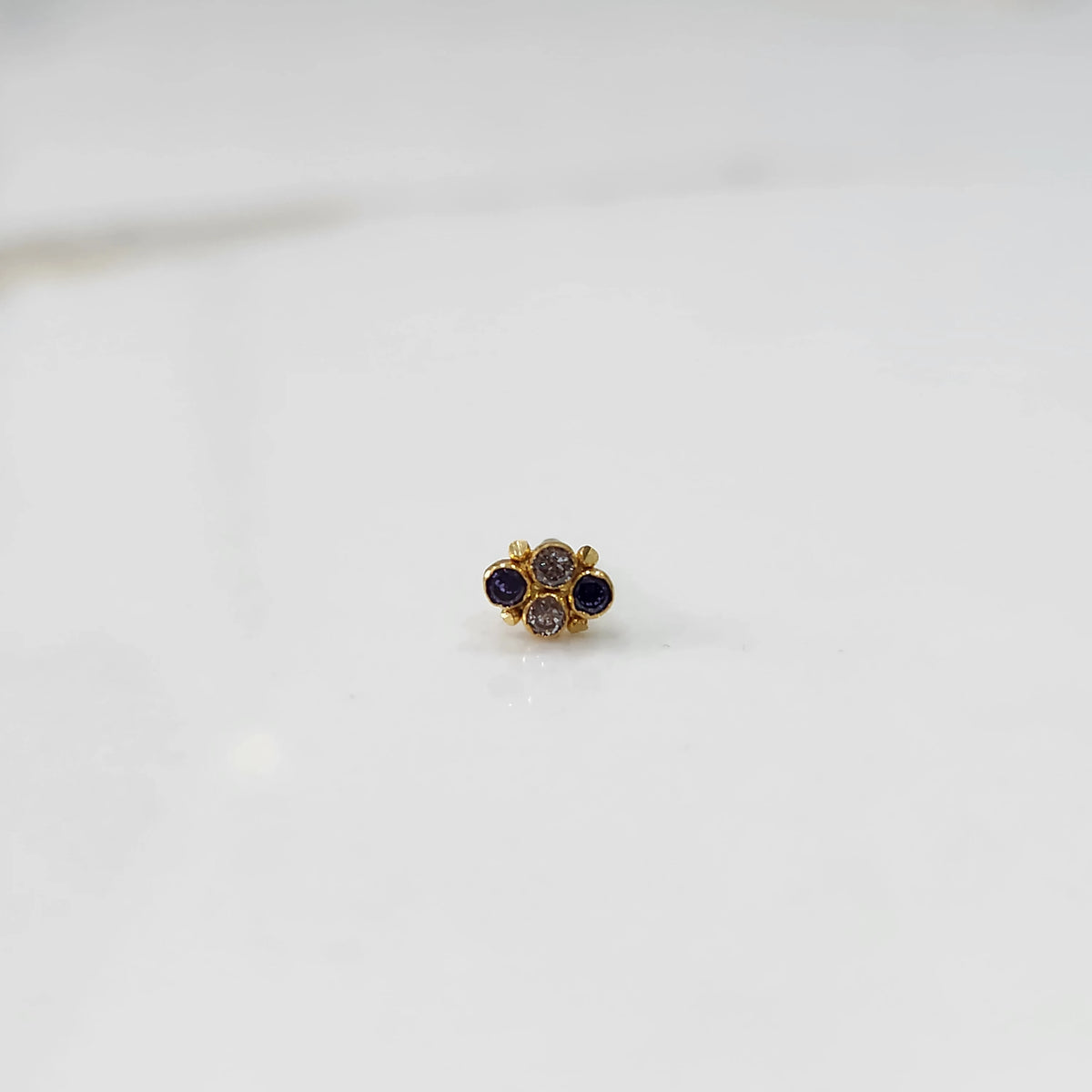 Women's gold nose pin design with small stone flower pattern