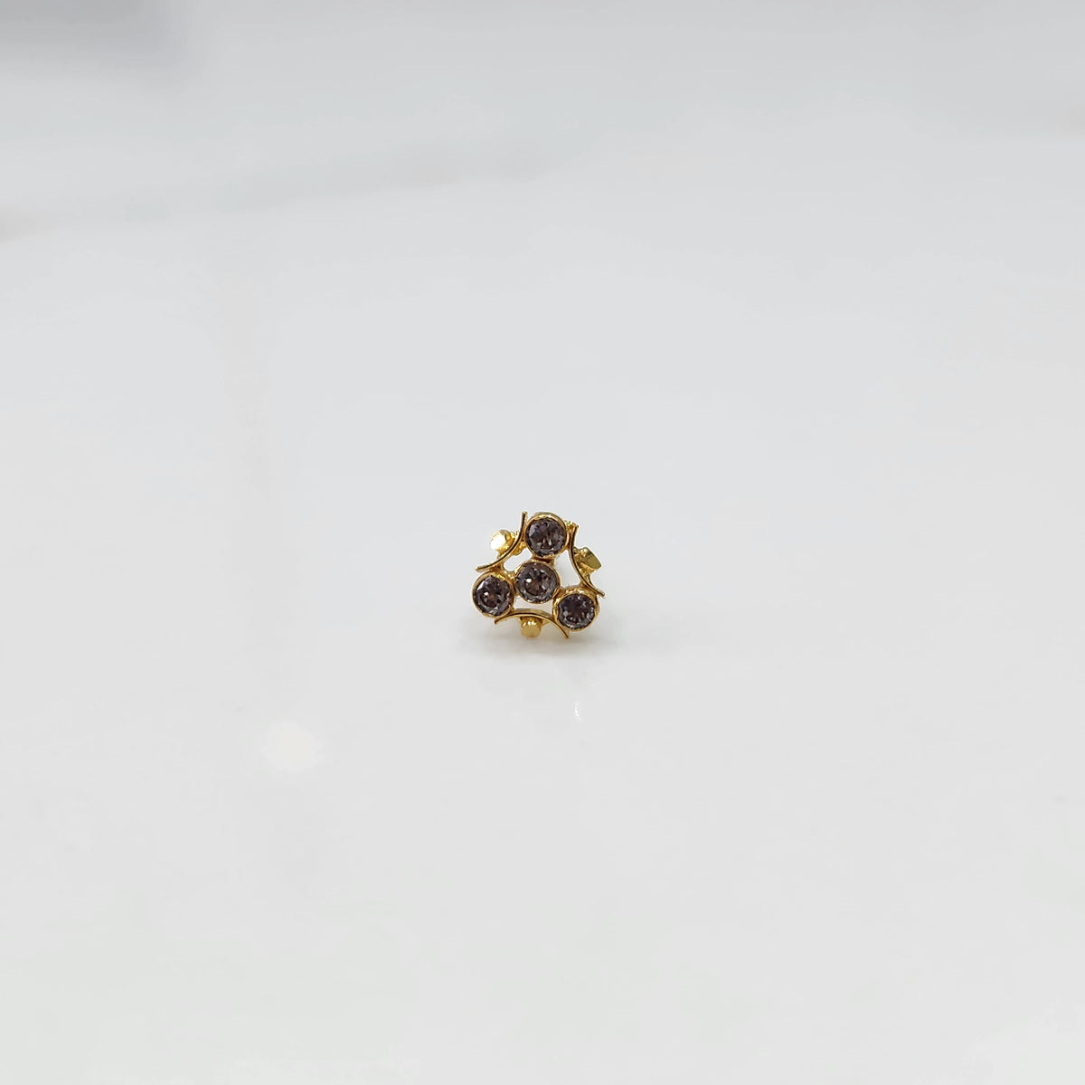 Traditional gold nose stud with four champagne stones in freeform gold setting
