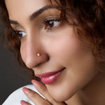 Woman wearing a small floral gold nose pin