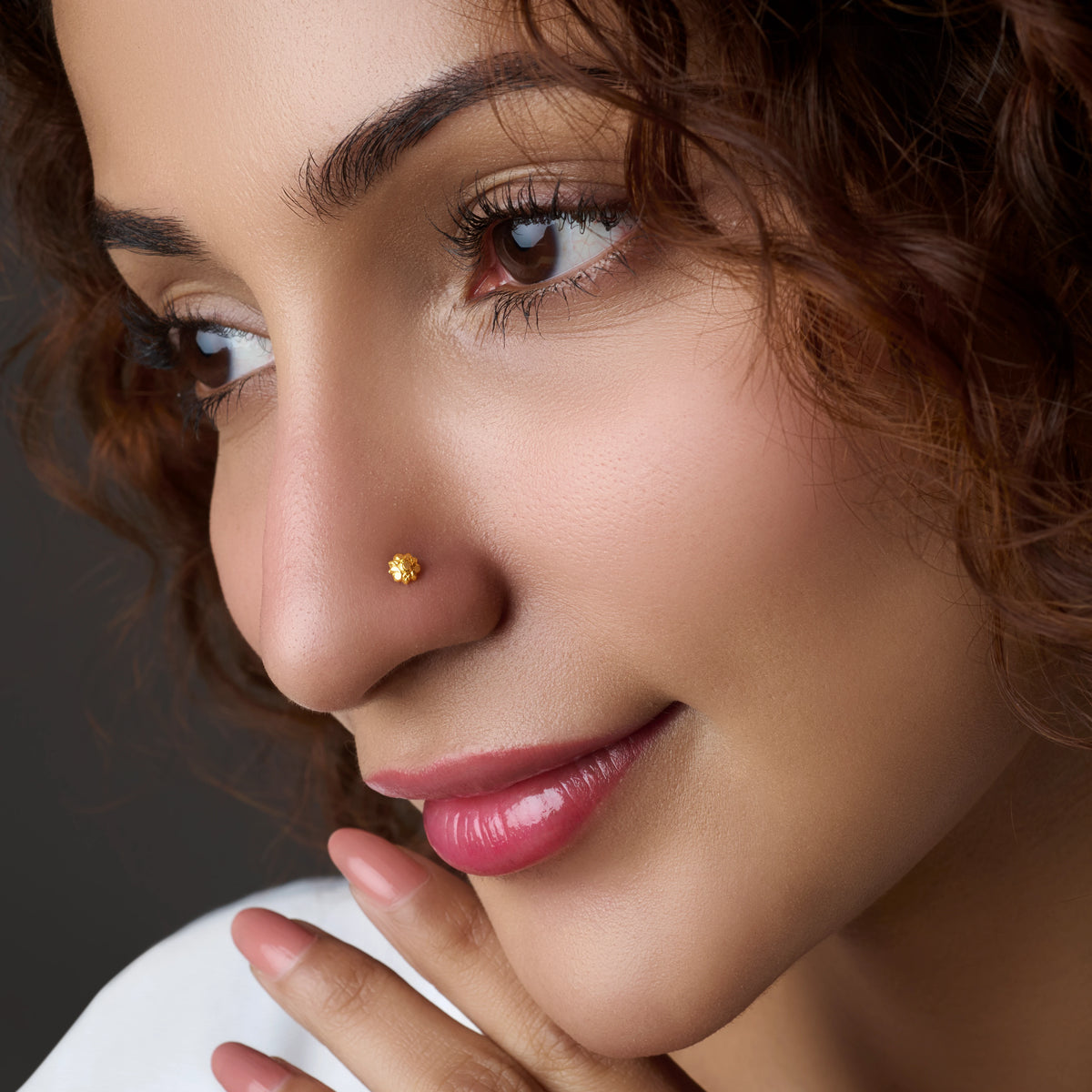 Woman wearing a small floral gold nose pin