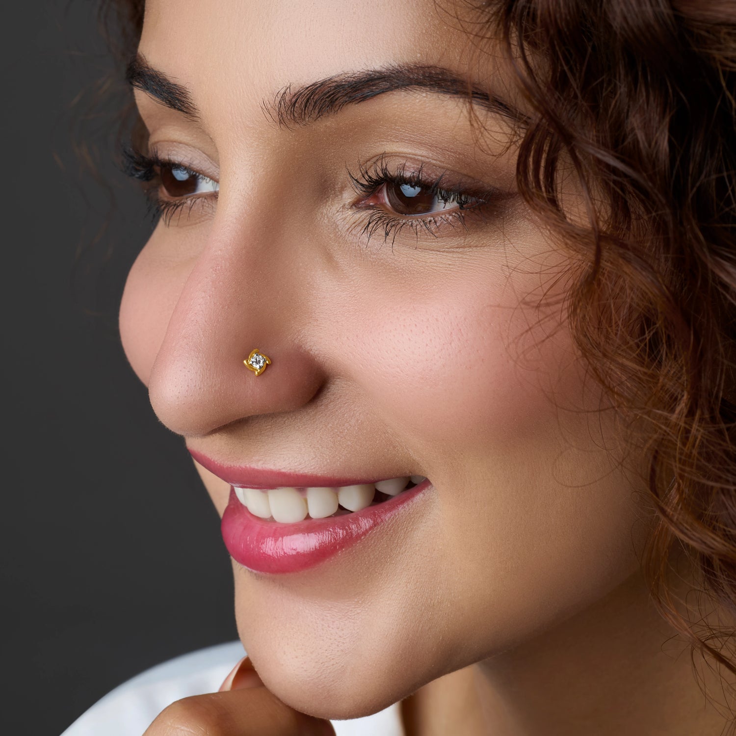 Woman smiling with a small gold nose pin