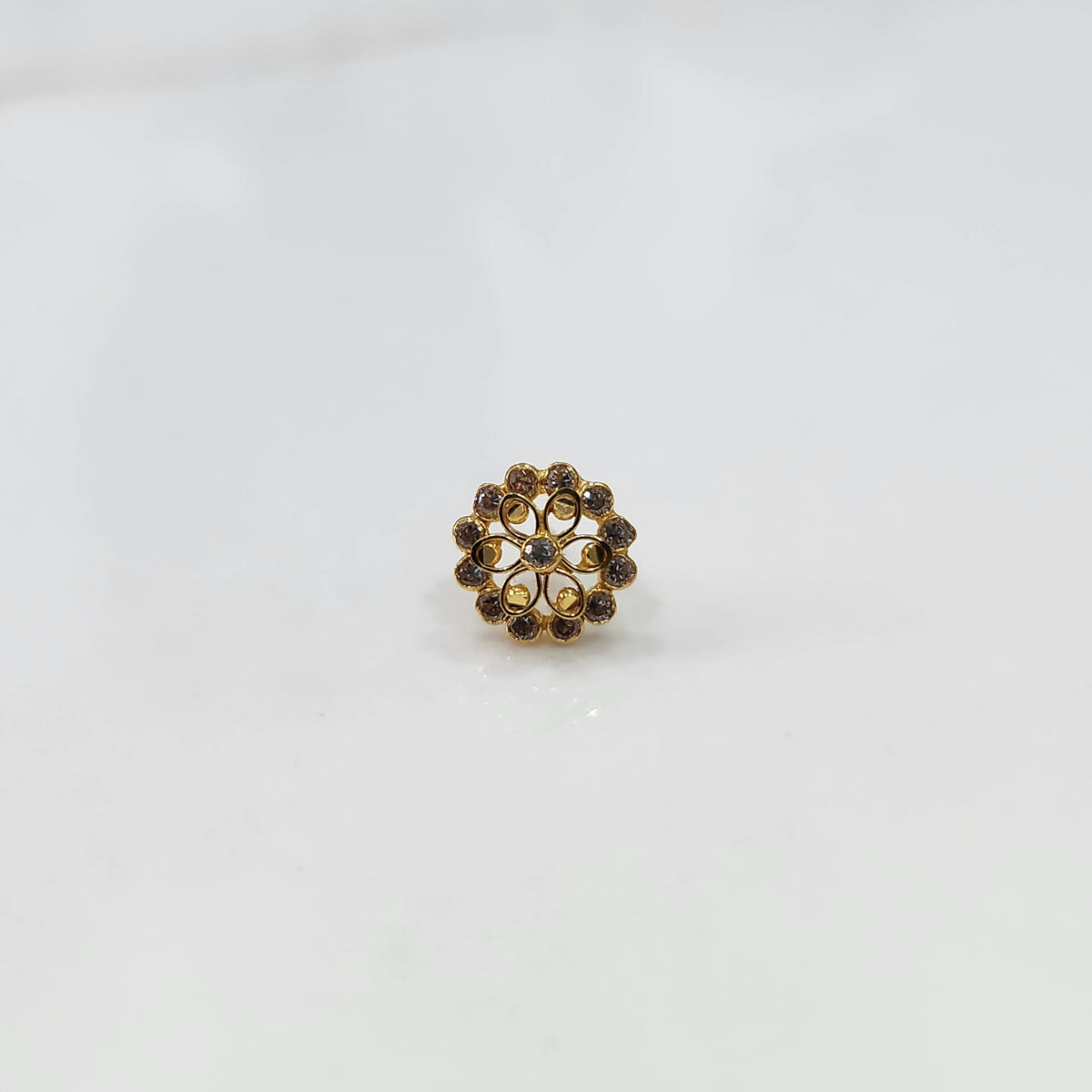 Gold nose pin design with white floral cluster on white background