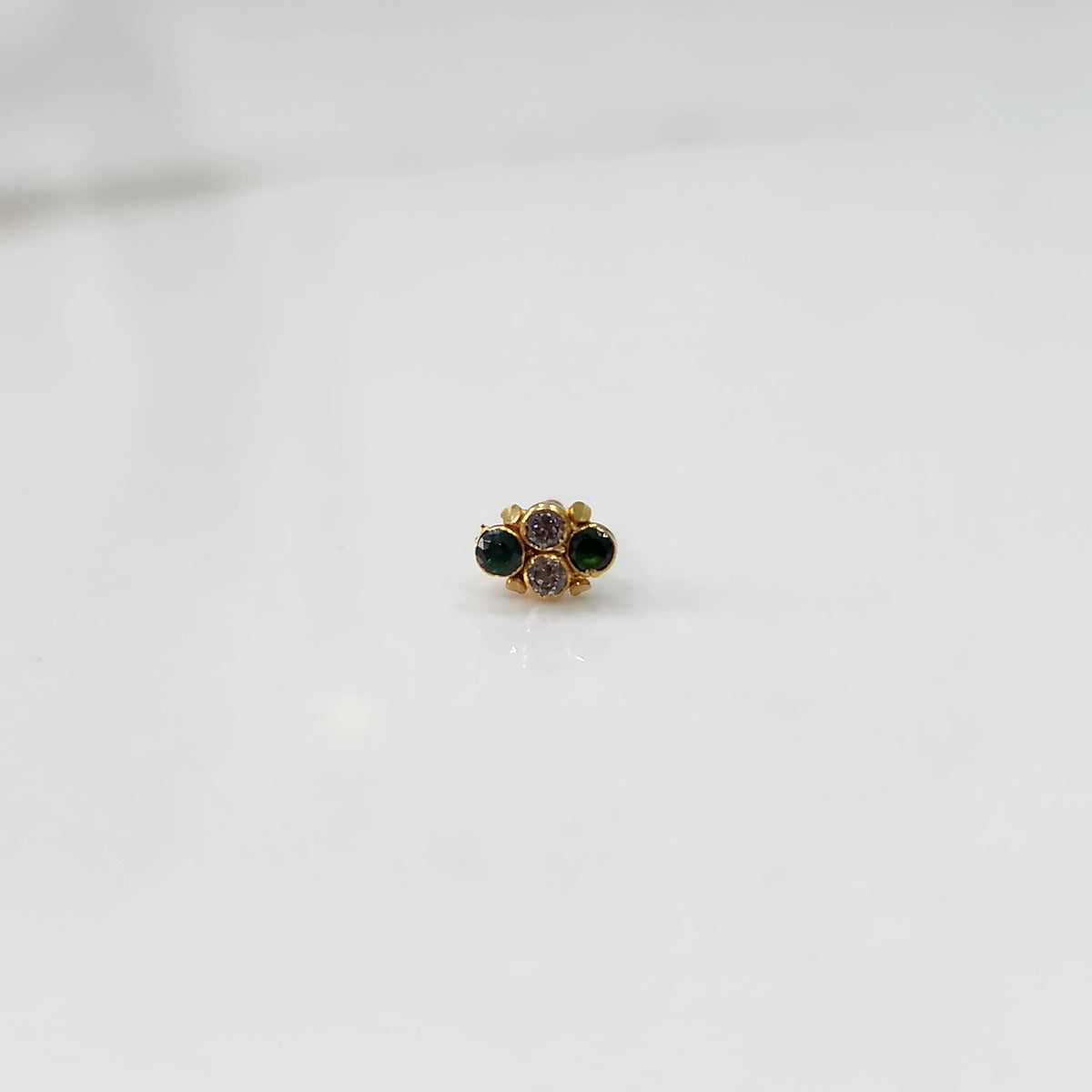 Gold nose pin with small green and purple stone cluster