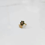 Gold nose pin featuring green floral cluster with purple accent and ornate curling detail