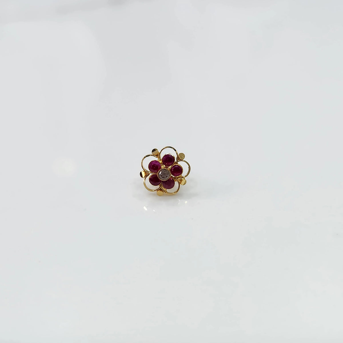 Gold floral nose pin with magenta stones and clear center stone
