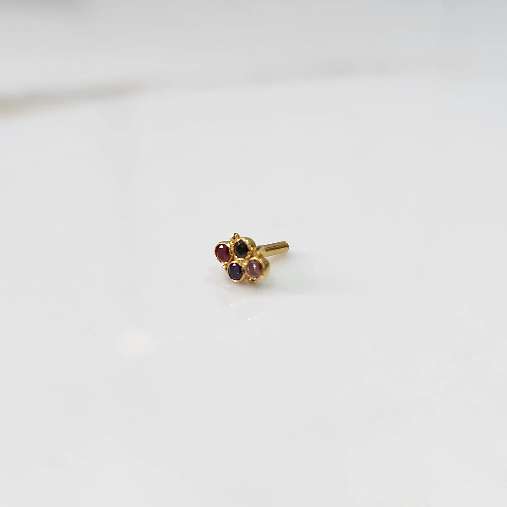 Women's gold nose pin design minimal floral gemstone cluster on white background