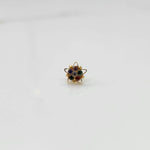 Nose pin design gold with green and red stones in floral pattern on white background