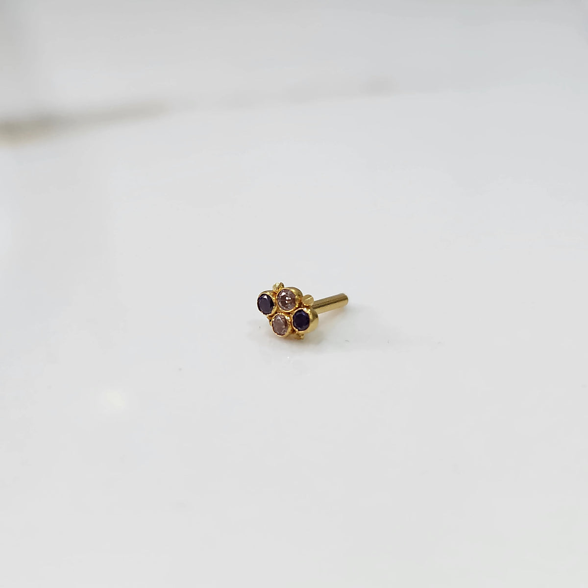 Women's gold nose pin design with floral cluster on white background