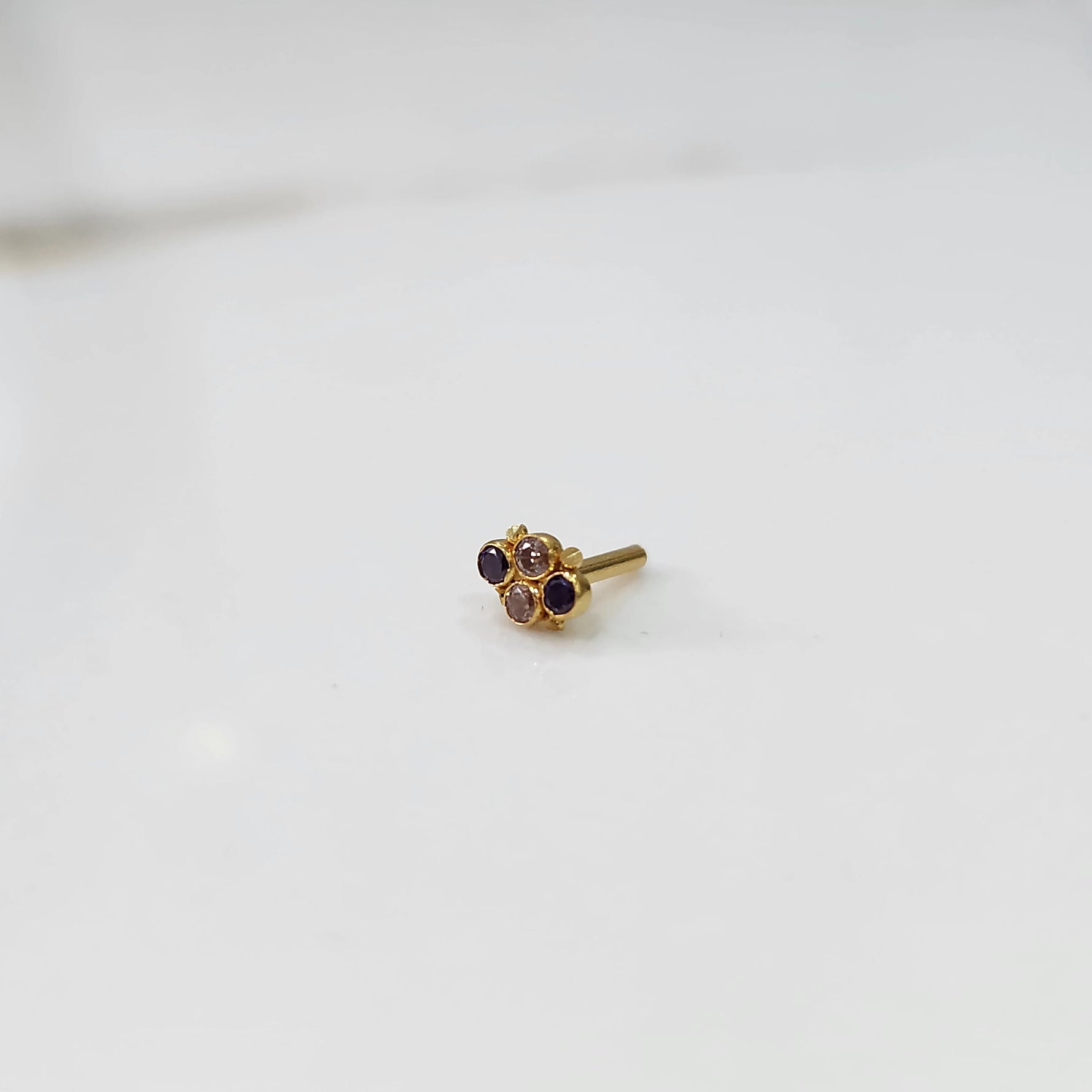 Women's gold nose pin design with floral cluster on white background