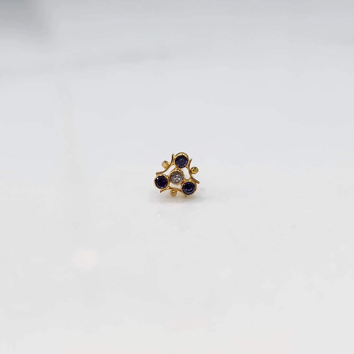 Tiny nose pin gold with floral pattern on white background