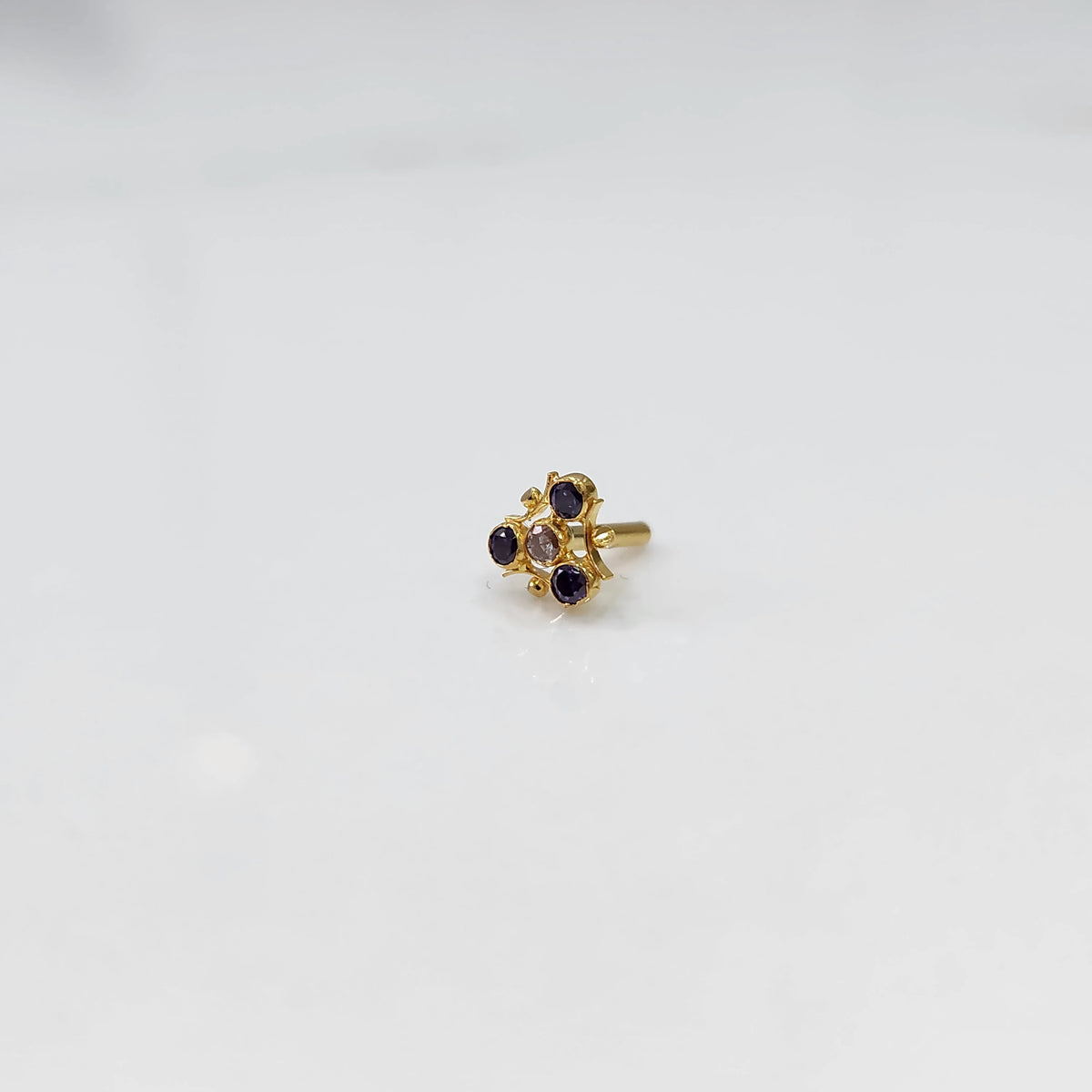 Gold nose pin with purple stone cluster in organic branch-style setting