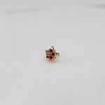 Gold nose pin featuring six-point star design with ruby and champagne stone cluster