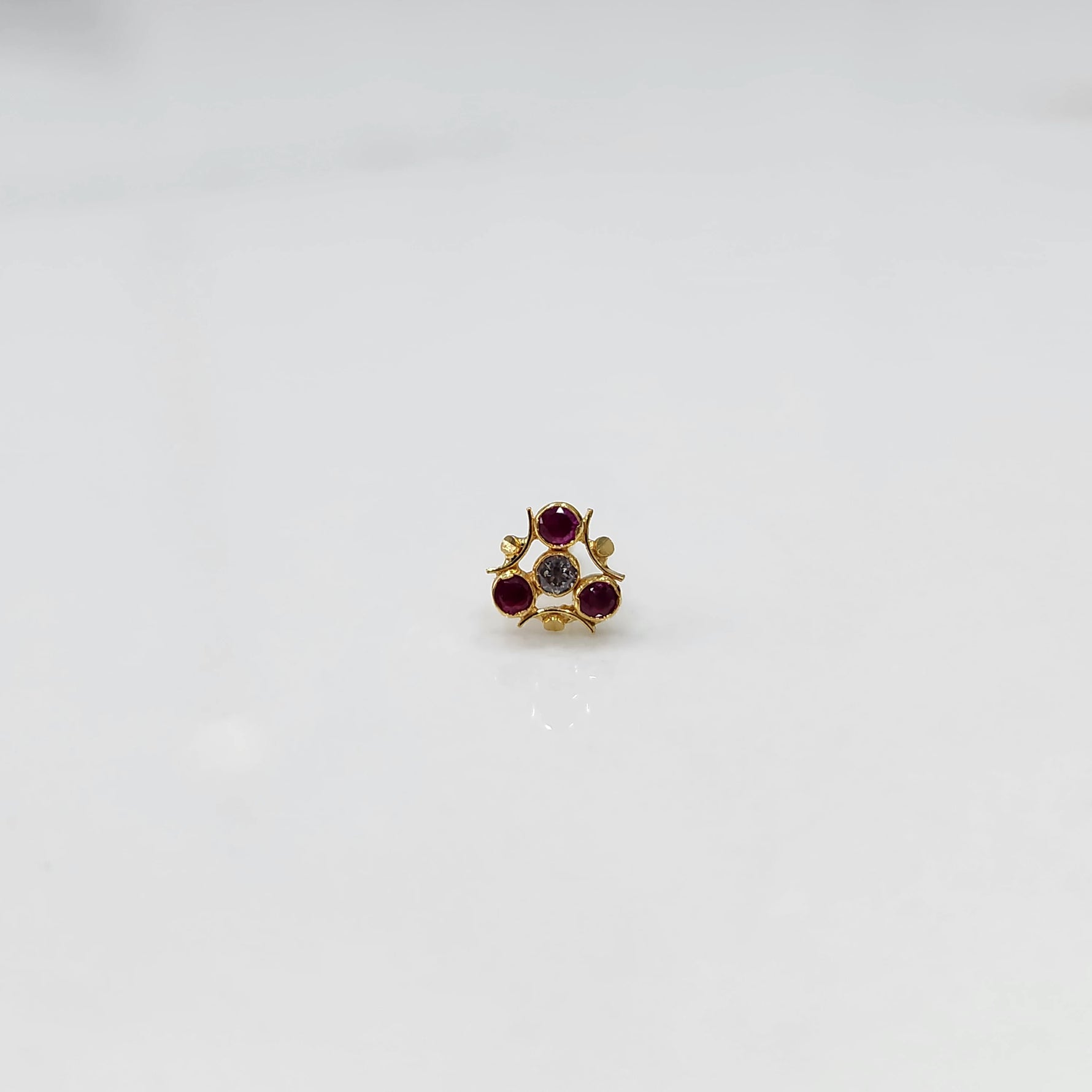 Gold nose pin with ruby and clear stones in organic branch-style setting