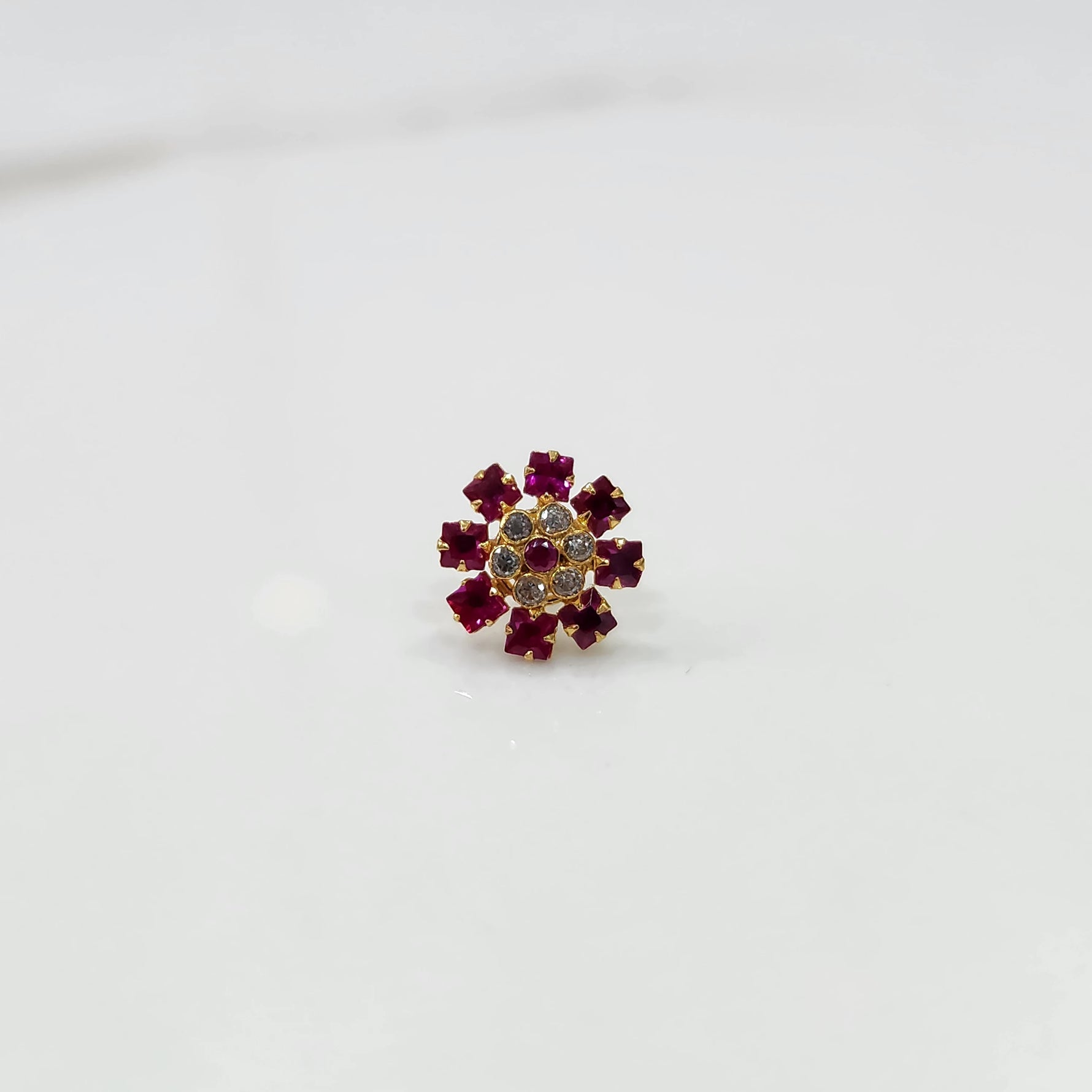 Gold nose pin with ruby square-cut stones and clear round center stones