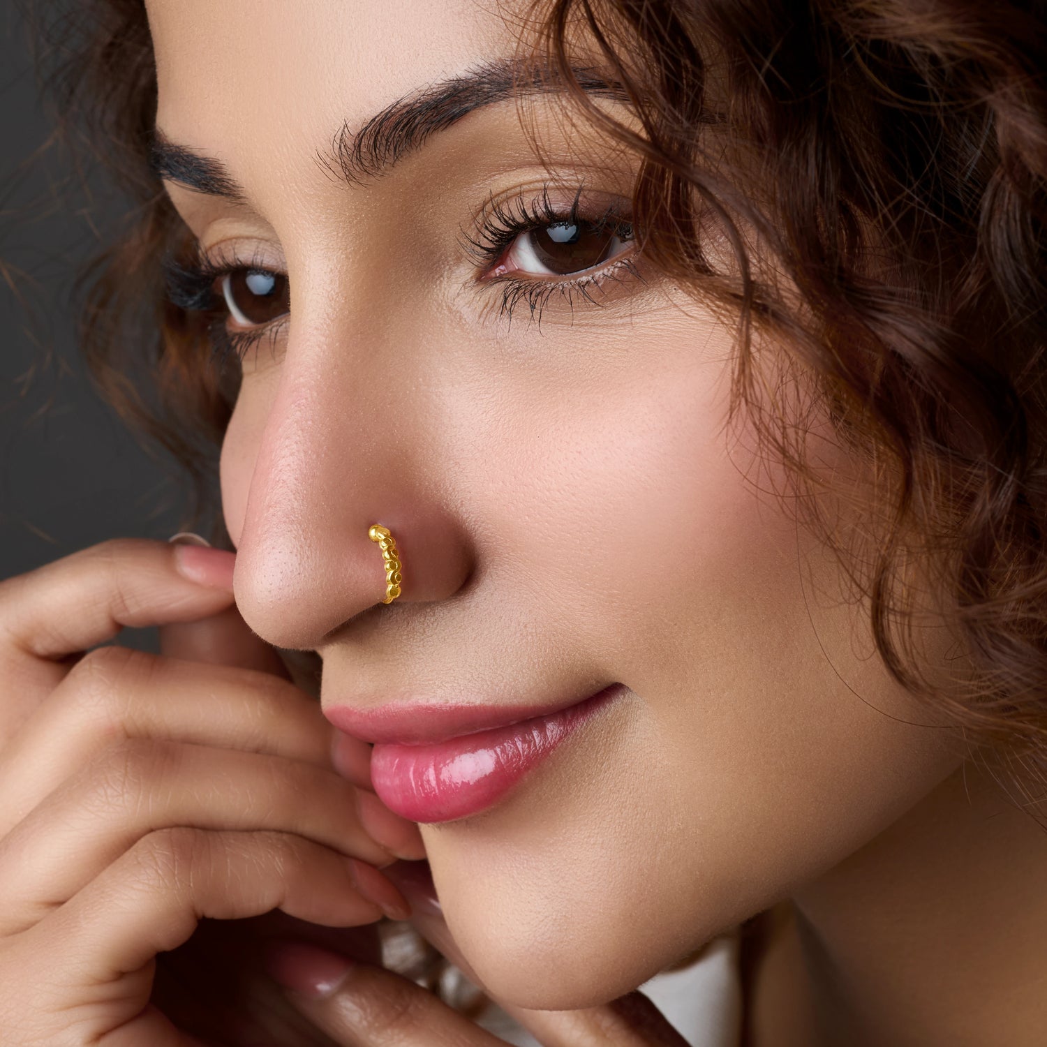 Woman wearing a thin gold nose ring hoop