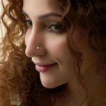Woman wearing single stone nose pin gold with classic round diamond style