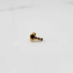 Gold nose pin with black floral head and linear stone trail