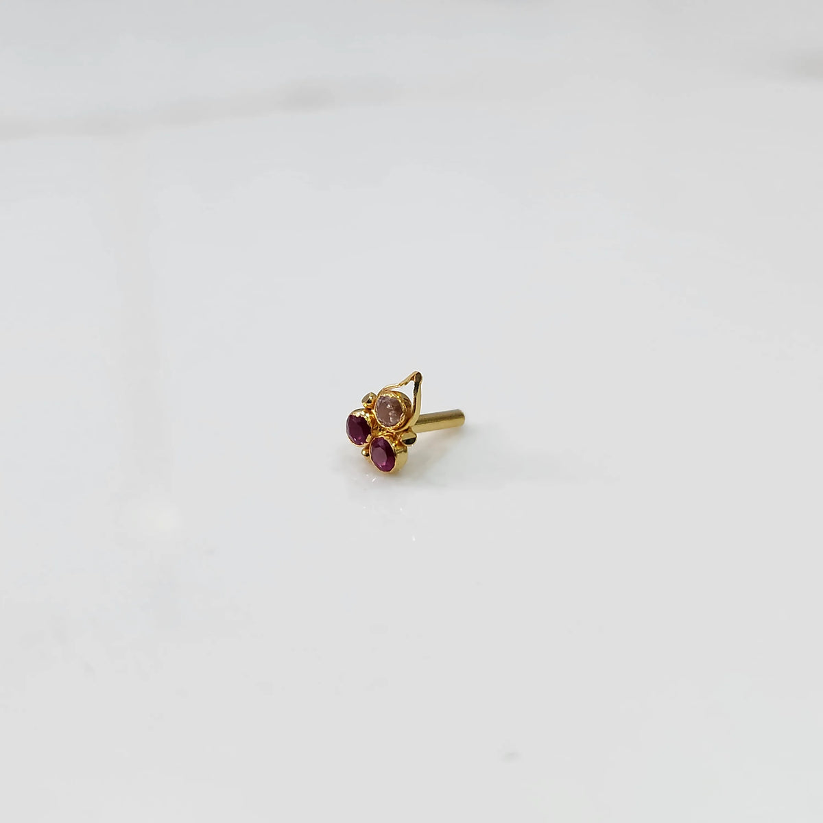 Gold statement ring with pink and red gemstones in cluster leaf design