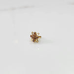 Gold statement ring with pink gemstones in floral starburst design, side angle view