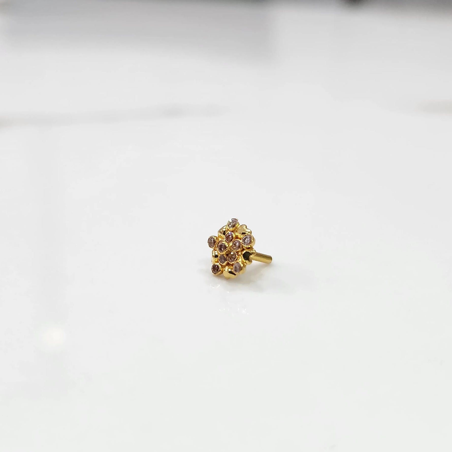 Gold statement ring with pink gemstones in textured flower cluster design