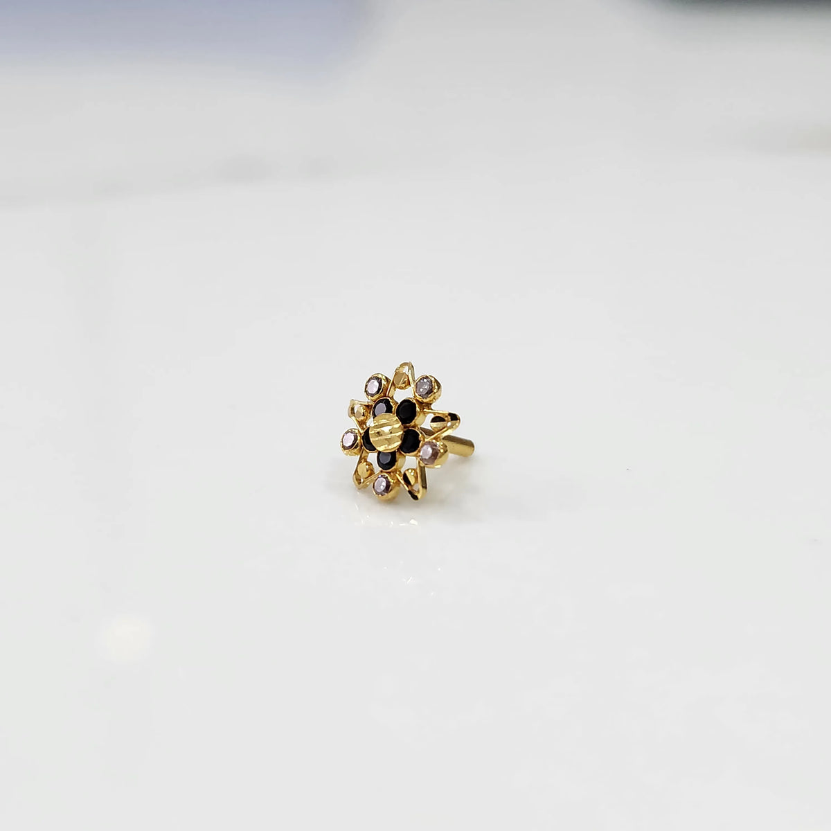 Gold ring with pointed petal design and black center stone