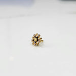 Gold ring with pointed petal design and black center stone