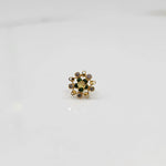 Top view of gold pointed petal ring with green center stones