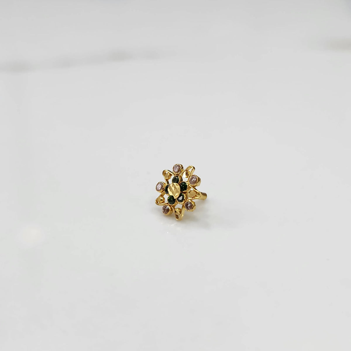 Gold pointed petal ring with green center and clear round stones