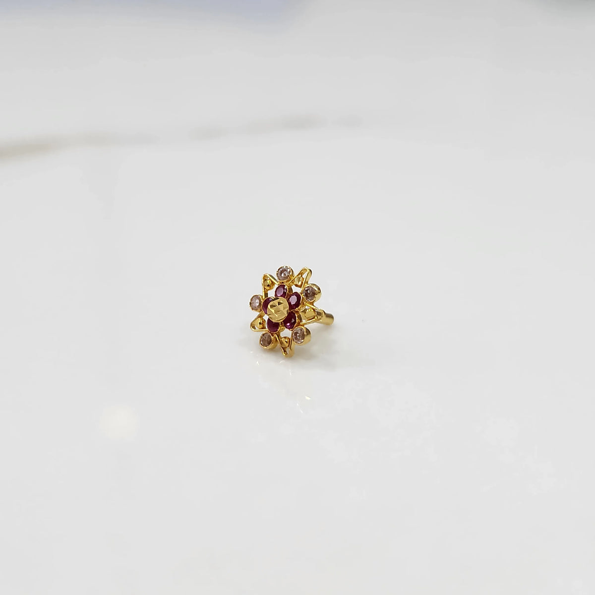 Gold pointed petal ring with red center and clear round stones