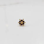 Close-up of gold statement ring with purple cabochon gemstones in scattered cluster design