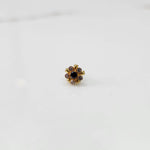 Gold floral nose pin with purple center stone, product shot