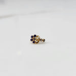 Gold nose pin with purple gemstone cluster and clear drop-style stone accent on white background