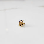 Gold statement ring with purple and clear gemstones in leaf-patterned cluster design