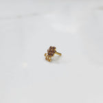 Gold nose pin with purple stones and clear accents, with curling swirl accent detail
