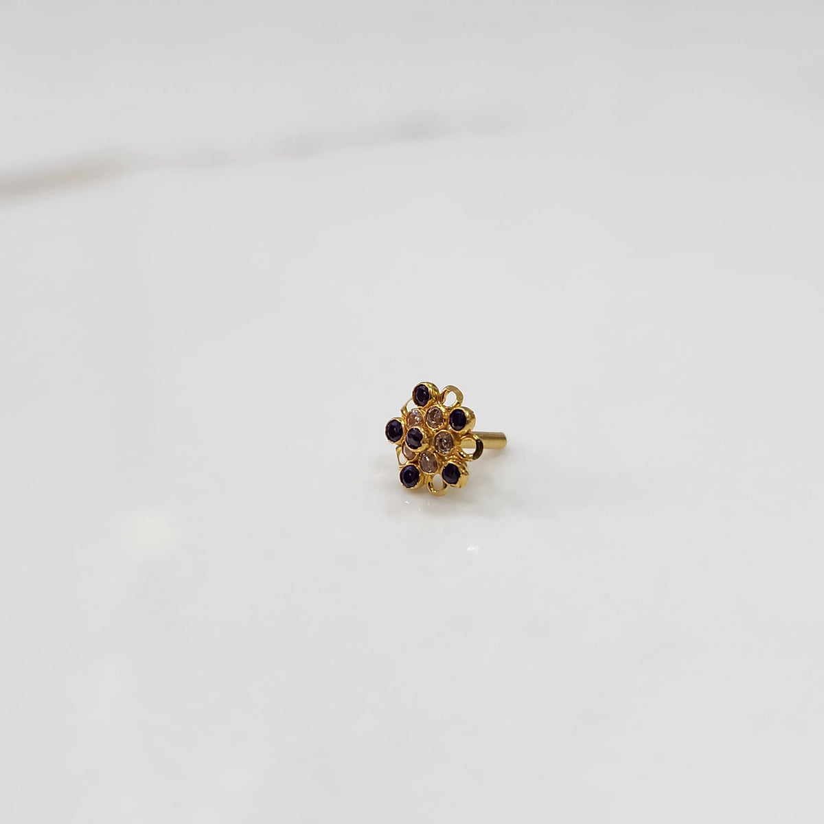 Gold nose pin with purple gemstone mandala design on white background