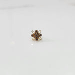 Gold cocktail ring with purple gemstones in atomic-style floral setting