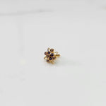 Gold statement ring with purple amethyst-tone gemstones in floral starburst design